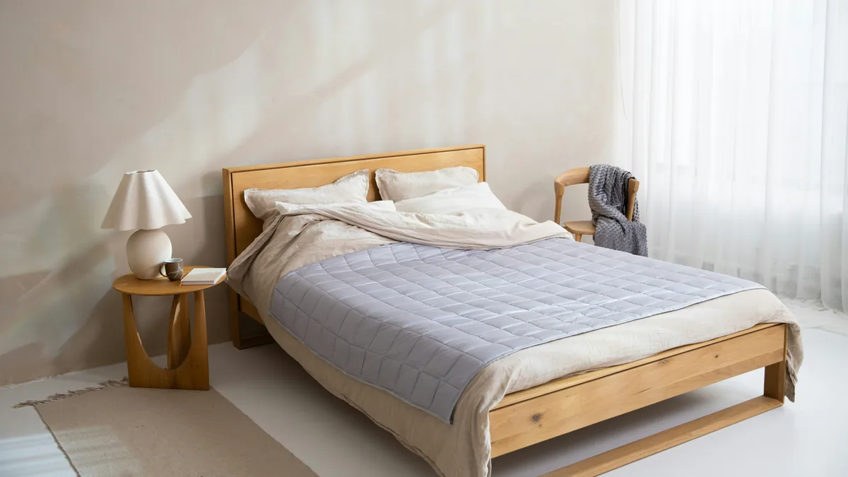 A made bed with a quilted mattress cover in a bright bedroom