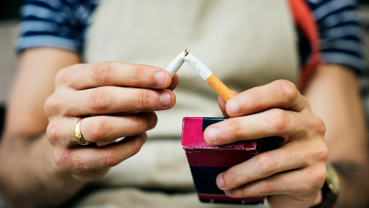 Hands snapping a cigarette in half – Pfizer Chantix class action