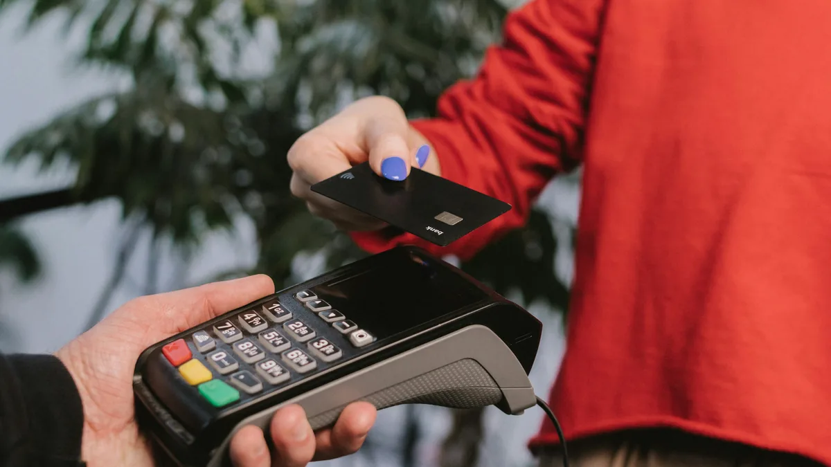 Customer tapping a card on a merchant's payment terminal – Discover Card merchant class action