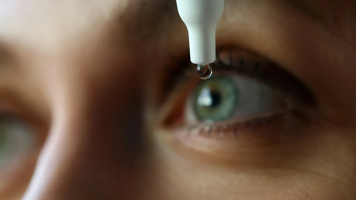 Eye drop about to fall into an open eye – CVS eye drops class action